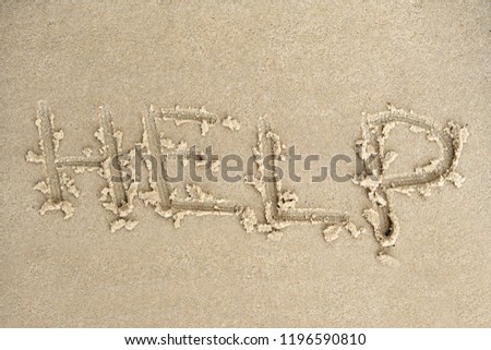 HELP inscription on sand