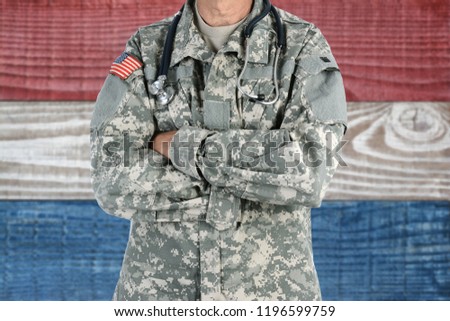 Closeup of an American Soldier Medic in front of a red, white and blue boards background. Patriotic background for 4th of July or Memorial Day projects.