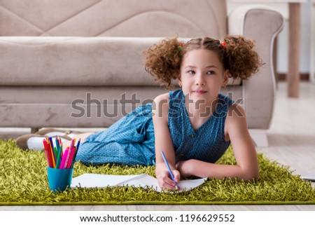 Young little girl drawing on paper with pencils