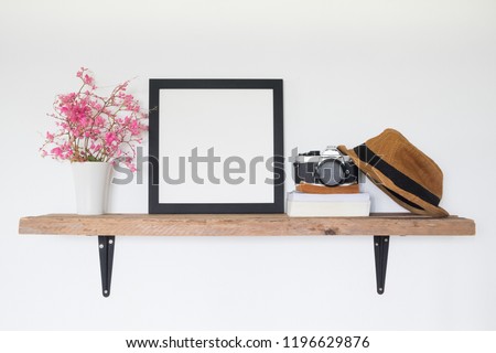 Mock up square frame photo on wooden shelf. Lifestyle traveler home decor concept