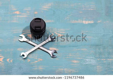 two keys and lens on wooden background. Camera repair and lens. Bad repair.