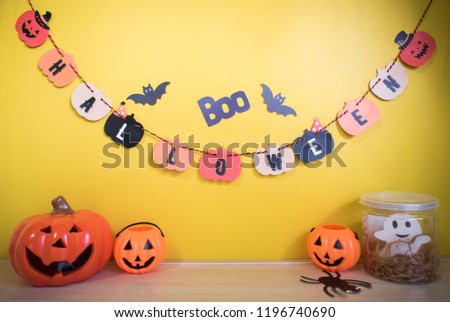 Halloween concept with halloween decoration and yellow wall with blank space for text.