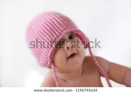 Portrait of baby girl in a pink warm hat