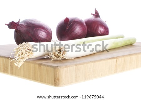 Picture of red onions and leeks on a cutting board