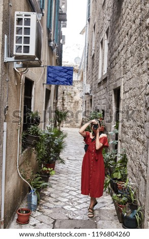 Montenegro. The Town Of Kotor. Streets of old Kotor. Young tourist girl taking pictures of the streets of the old city. Summertime.