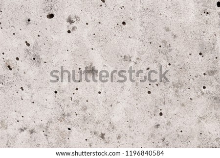 Lightly weathered concrete background with pitted textured surface