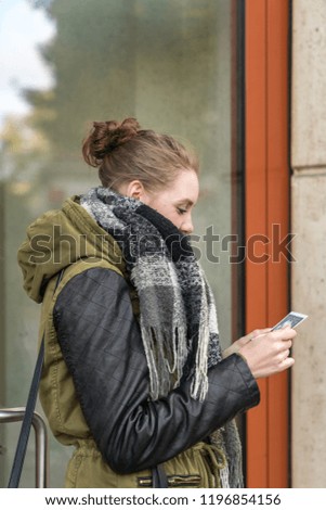 Young pregnant woman in fron of a building holding a ultrasonic in her hand