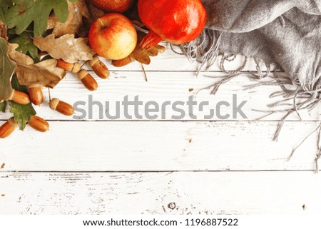 Autumn composition of dry leaves, apples and acorns on a white wooden table. Top view. Copy space