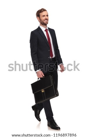 happy young businessman holding briefcase walks to work to side on white background, full body picture
