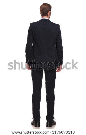 rear view of elegant businessman in suit standing on white background and looking to side, full body picture