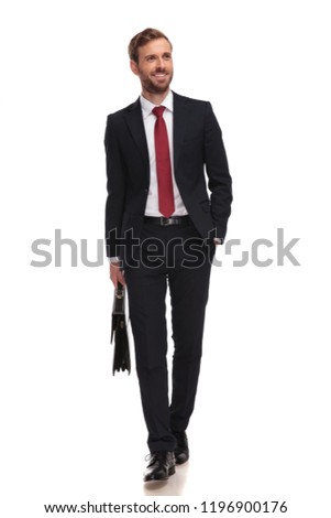 relaxed businessman with briefcase walking on white background and looking up to side, full length picture