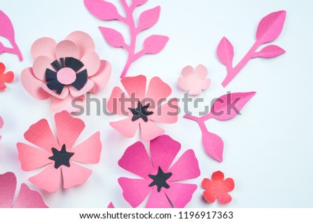Flower and leaf of pink and black color made of paper. Handwork, favorite hobby. White background.