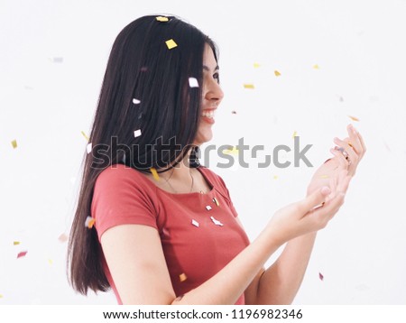 Happy young woman standing over white background with glitter paper,celebration concept.