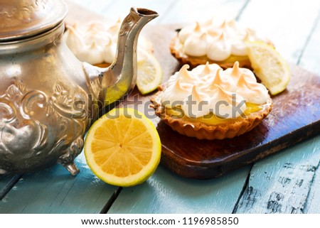 Meyer Lemon Tartlets with Lemon Curd and silver teapot, traditional arabic tea in pot 