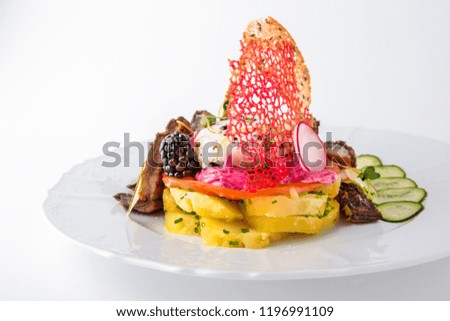 Boiled potatoes with salted and smoked fish, vegetables and berries. Banquet festive dishes. Gourmet restaurant menu. White background.
