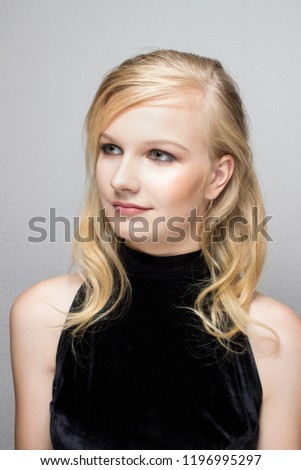Beautiful party smoky eyes make up and hair. Blonde girl in black dress smiling portrait. Halloween, Christmas party costume concept