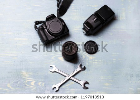 two keys and lens on wooden background. Camera repair and lens. Bad repair.