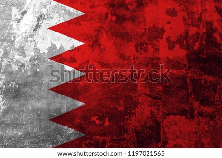 National flag of Bahrain on the background of the old wall covered with peeling paint
