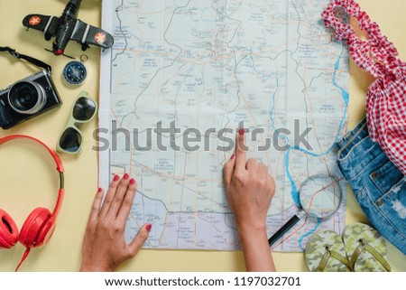 Woman traveler are planning trip by searching the route on the map and searching for information on the internet.