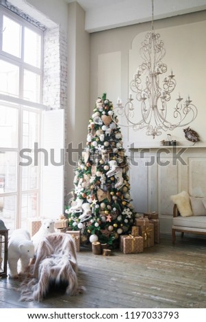 Christmas morning interior with decorated xmas tree and big window. White loft. Vintage chandelier. Beige sofa. White and gold balls on the Christmas tree. Polar bear. New Year. 
Open sledge