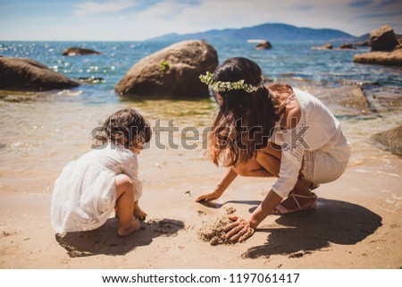 Lifestyle portrait mom and daughter in happines at the outside in the meadow.Happy loving family. Mother and child girl playing, kissing and hugging.Asian mother and daughter walking on the beach.