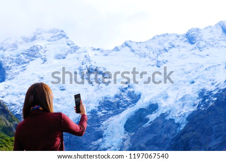 Tourist taking photo beautiful landscape panoramic view of snow mountain at view point Aroki mountain New Zealand.