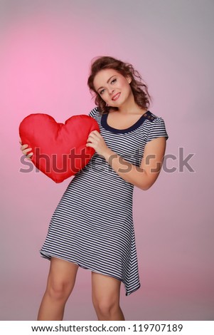 Studio portrait of happy smiling woman with heart symbol/girl with heart symbol