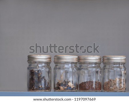 Set of many herbs in glass bottles, the secret of eastern long life with light gray background. Art design concept with a lot of space in top of the picture.