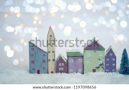 Christmas and New Year miniature houses with fir trees on lights background. Copy space for text. Winter card. Holiday and celebration concept.