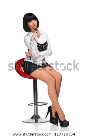 Young woman sitting on a chair with pen and glasses on white background