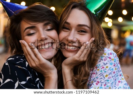 Image of happy young women friends outdoors in park having fun looking camera.