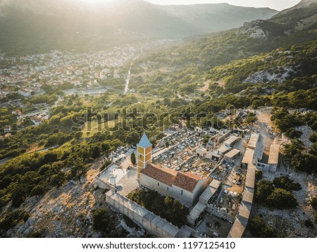 Castle of Baska overlooking the city and Adriatic sea in evening sunrays.