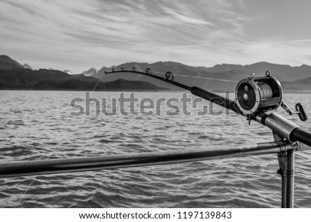 Black and White Photo of a Deep Sea Fishing Rod and Reel in a Rod Holder on the Gunnel of a Boat in Alaska