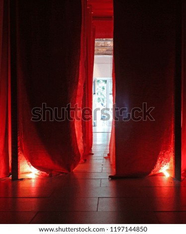 Red curtains with floor lights and entrance in the middle Royalty-Free Stock Photo #1197144850