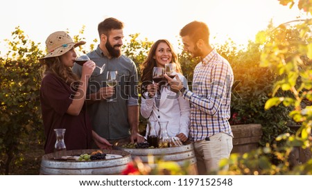 Happy friends having fun drinking wine at winery vineyard - Friendship concept with young people enjoying harvest time together Royalty-Free Stock Photo #1197152548