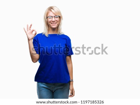 Young beautiful blonde woman wearing glasses over isolated background smiling positive doing ok sign with hand and fingers. Successful expression.