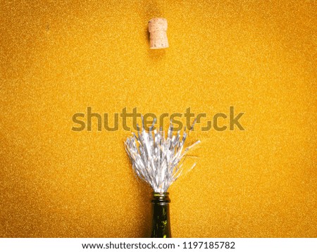 From above opened  bottle with silver decoration simulating champagne and cork on golden background