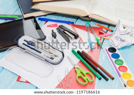 School supplies on wooden blue background. pencils, markers, paints,