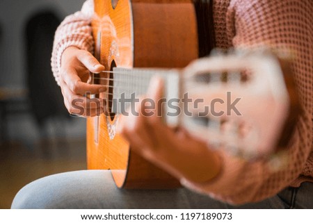 close up of woman  hand pressing chords on guitar's bar, music and art concept