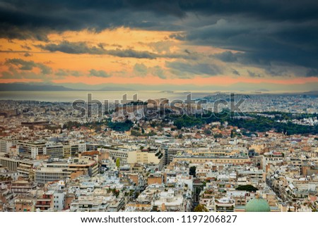 Acropolis of Athens Greece at cloudy sky sunset and the rain at the right side of the image with the sea and mountains at the background