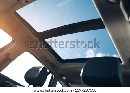 Panoramic glass sun roof in the car. Clean glass and view from inside to the sky Royalty-Free Stock Photo #1197207538
