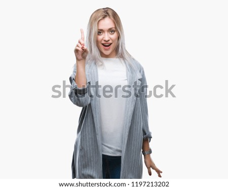 Young blonde business woman wearing jacket over isolated background pointing finger up with successful idea. Exited and happy. Number one.