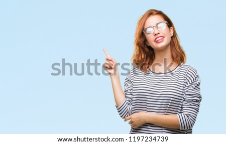 Young beautiful woman over isolated background wearing glasses with a big smile on face, pointing with hand and finger to the side looking at the camera.