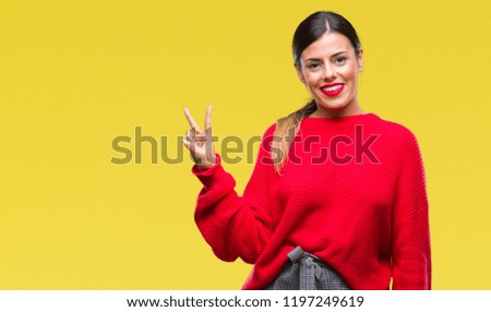 Young beautiful business woman wearing winter sweater over isolated background smiling with happy face winking at the camera doing victory sign. Number two.