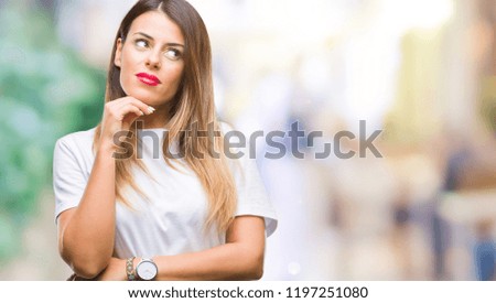 Young beautiful woman casual white t-shirt over isolated background with hand on chin thinking about question, pensive expression. Smiling with thoughtful face. Doubt concept.