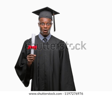 Young graduated african american man holding degree over isolated background scared in shock with a surprise face, afraid and excited with fear expression