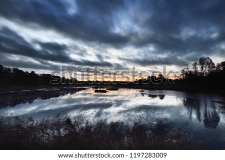Reflections on the water. A view of the forest lake at sunrise. Autumn. Latvia