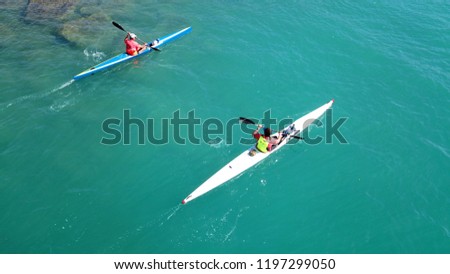 Aerial drone bird's eye view of sport canoe operated by a man in turquoise clear waters