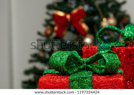 Christmas red boxes with green lace lights, christmas images, christmas trees in blurred background.