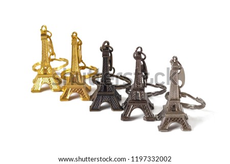 Golden, dark and silver trinkets in the shape of the Eiffel tower isolated on white background